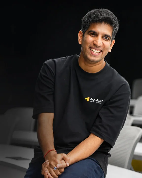 Mukul Rustagi, co-founder of Polaris School of Technology, smiling, seated in a Polaris T-shirt